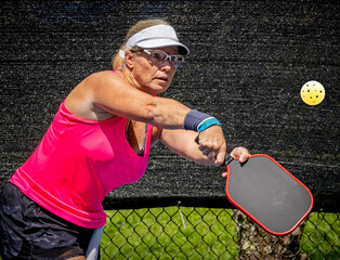 Female pickleball player hits a volley shot while keeping her eyes on the ball.tif