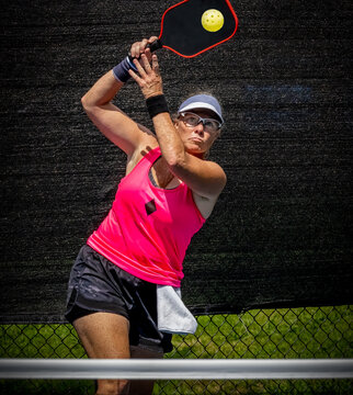 Female pickleball player about to smash the ball for a winner
