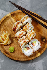 Sushi roll dragon with smoked eel and shrimp. Traditional delicious fresh sushi roll set on a black background. Sushi menu. Japanese kitchen, restaurant. Asian food