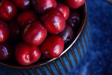 Coupe bleue avec des cerises rouges.