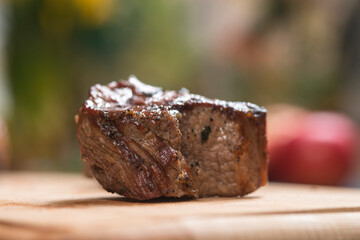 Closeup of grilled meat chunks served on wooden board