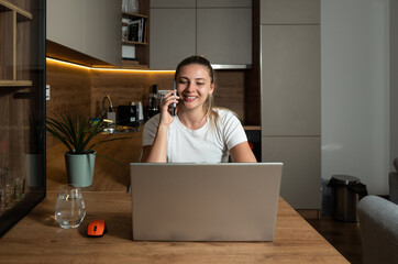 Young smiling woman or girl talking on the phone with internet provider customer service working on finding solution for bad connection and operator is kind and promised one month free internet.