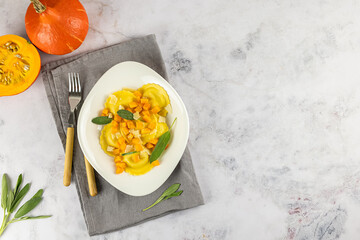 Seasonal autumn recipe. Pumpkin ravioli with sage, parmesan, and olive oil. Great meal for lunch or dinner, vegetarian food. Copy space, top view.