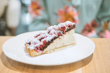 Closeup photo of woman eating piece of cake with raspberries