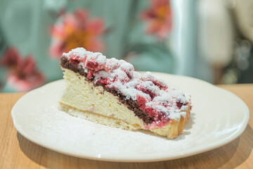 Closeup photo of woman eating piece of cake with raspberries