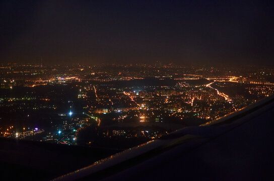 Fototapeta view from the window of the plane on the night city. bird's eye view of city lights at night