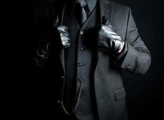 Portrait of Mysterious Man in Black Suit and Gloves. Concept of Mafia Hitman or Hotel Concierge. - obrazy, fototapety, plakaty