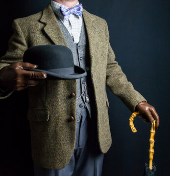 Portrait of British Man in Tweed Suit and Leather Gloves Holding Umbrella and Bowler Hat. Classic Style of English Gentleman