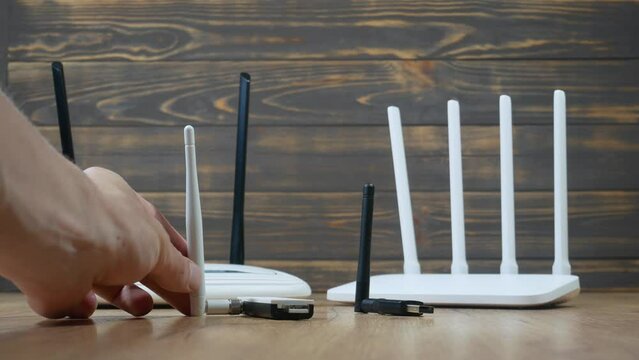 Man choose of different types of Wi-Fi routers, modern and old technology. Wireless ethernet connection signal. USB Wifi Receiver Wireless Network Card. High Speed Antenna Wifi Adapters.