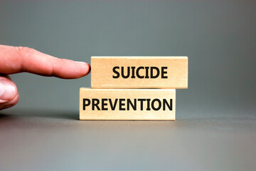 Suicide prevention symbol. Concept words Suicide prevention on wooden blocks. Beautiful grey table...