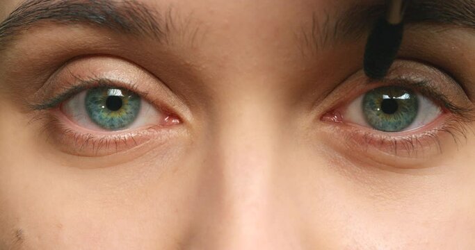 Beauty, cosmetics and makeup for eyes of woman, mascara and cosmetic brush for beautiful facial look. Face or eye zoom of young girl or makeup artist in process of creating natural eyelash design