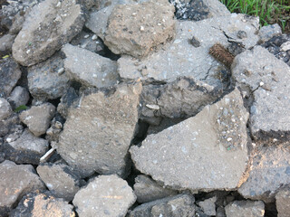pieces of old removed broken asphalt are lying around in a heap