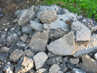 pieces of old removed broken asphalt are lying around in a heap