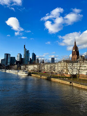 Fototapeta na wymiar View of the business corporate downtown bank district with high tall skyscraper buildings, Saint Bartholomeus's Cathedral, and Eiserner Steg bridge over the Main River in Frankfurt am Main, Germany.
