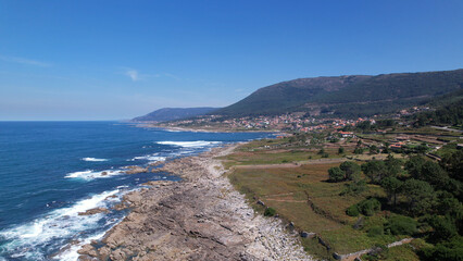 AERIAL VIEW - Summer Atlantic Ocean rocky coast landscape in the autonomous community of Galicia, Spain. Rocky coast with sea waves beating.