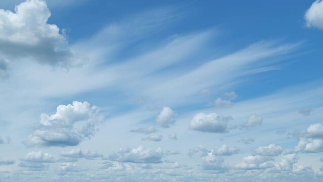 Cirrostratus with cumulus clouds flying slowly on beautiful blue sky horizon background. Timelapse.