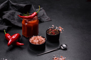 Glass jar with homemade classic spicy tomato pasta or pizza sauce with spices and herbs