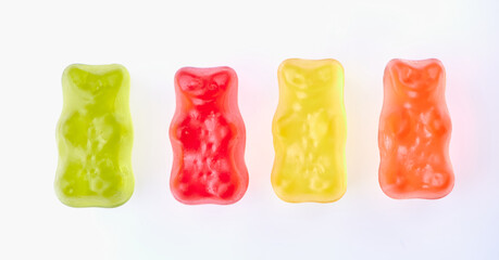 four gummy bears in different colors on white background
