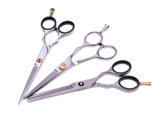 Composition of three professional hairdressing scissors for cutting and thinning hair of different designs. Isolated on white background. Tools for a hairdresser, provision of hairdressing services - obrazy, fototapety, plakaty