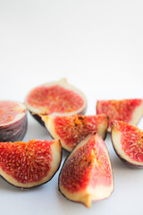 Photo of a fig close-up on a white background. Ripe fruit whole and in pieces.