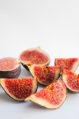 Photo of a fig close-up on a white background. Ripe fruit whole and in pieces.