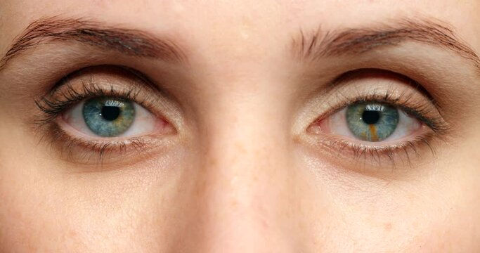 Woman, blue eyes and thinking with anxiety, worry and stress in blink motion. Zoom on portrait, face and skin of a model with stress, paranoid and contact lenses with texture detail, vision and fear