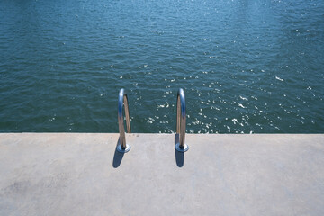 Swimming pool ladder on a concrete pier on a sea port of the Mediterranean sea