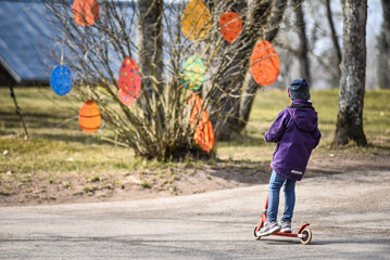 A child rides a scooter in a country park