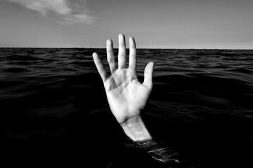 hand on the sea  of a person who is drowning with balck and white effect