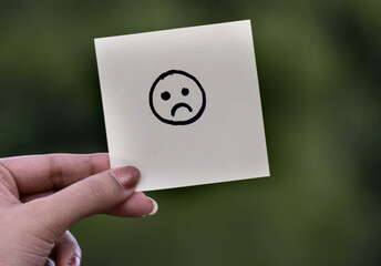 Emoji or drawing of happy expression face on blank note pad or sticky notes.