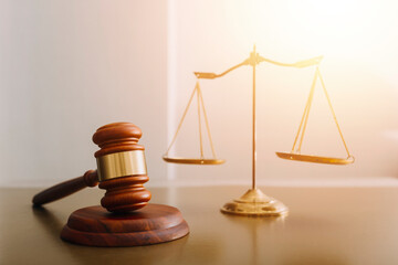 Justice and law concept.Male judge in a courtroom with the gavel, working with, computer and docking keyboard, eyeglasses, on table in morning light