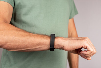 Man looking at fitness bracelet for walking steps, running distance, heart rate or sleep patterns...