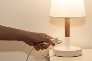 Switch off Lamp. Woman Hand Turning off lamp in the bedroom, concept Save Energy.