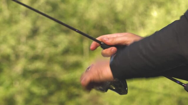 A fisherman catches fish in the river with spinning. Fishermen on the river bank. Salmon fishing in the river