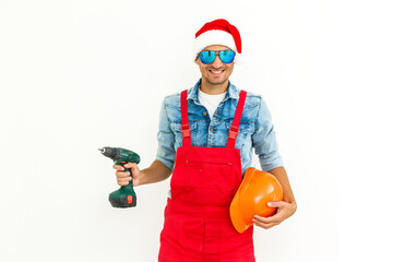 The guy, in uniform and Santa's hat, holds a drilland. Isolated on white background.