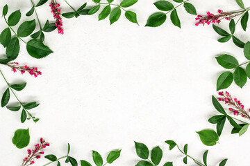 Floral pattern made of green leaves, branches on textured light background. Flat lay, top view. Valentine's background. Floral pattern. Pattern of flowers. Flowers pattern texture