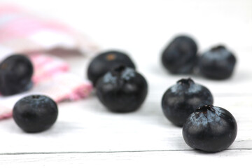 close up photo of blueberry on a napkin on wooden background