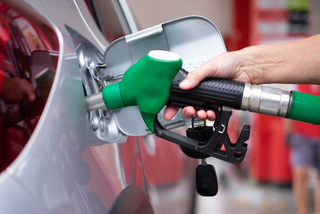 Woman's hand filling fuel into the car tank at the pump service station, for concept transportation power business rising prices inflation