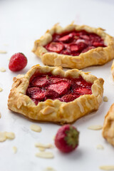 Mini biscuits with strawberries. Small berry pies on a white background.