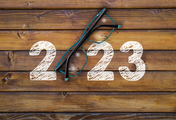 Happy new year 2023 Year 2023 with glasses on wooden table
