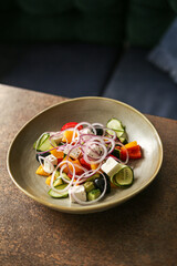 Greek salad close up with feta cheese, tomatoes, olives and green leafs.