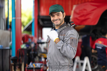Portrait engine maintenance car mechanic with holding wrench self-confident with looking at camera. diagnostic and repairing vehicle at garage automotive, Car care check and fixed services concept.