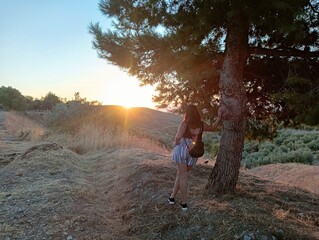 Chica divisando el atardecer en el bosque después de un intenso día de trabajo en la ciudad 