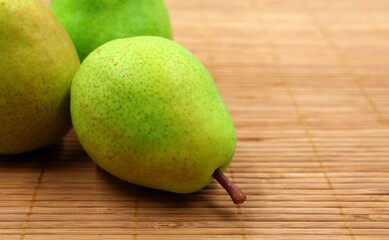 Green Belgian pears on a wooden background.