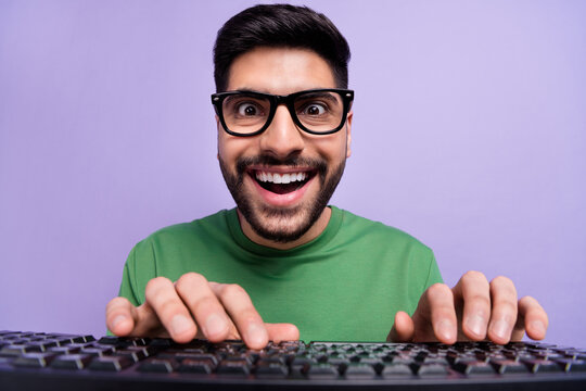 Photo of handsome geek nerd coder in spectacles green pullover writing code making new application isolated on purple color background