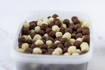 Chocolate and vanilla balls. Quick breakfast of corn snacks close-up