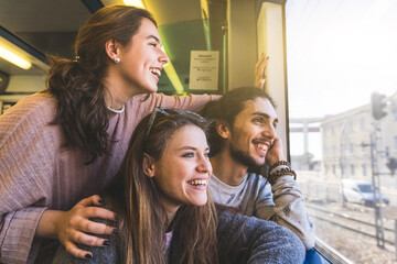 Happy group of friends looking out of train window