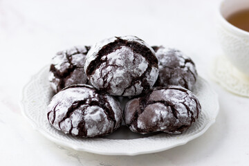 Cookies chocolate cracks on a white marble table. Biscuits and a cup of tea