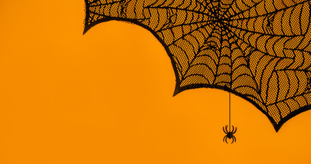 Fototapeta premium Halloween party background. Spider web on orange with a spider.