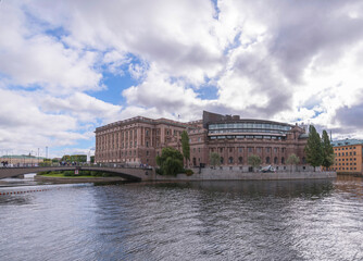 The Swedish Parliament on the island Helgeandsholmen in the stream Norrström with troubled water a cloudy autumn day in Stockholm 